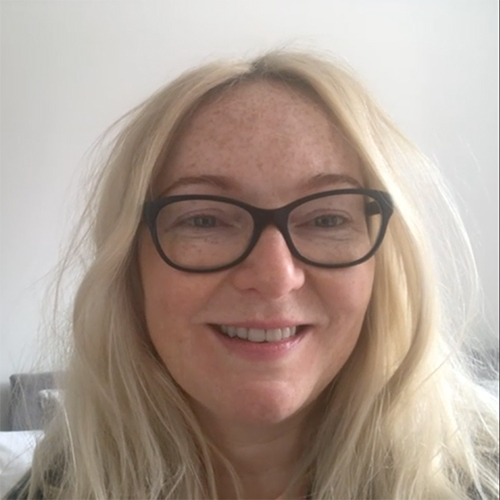 A woman in glasses smiling