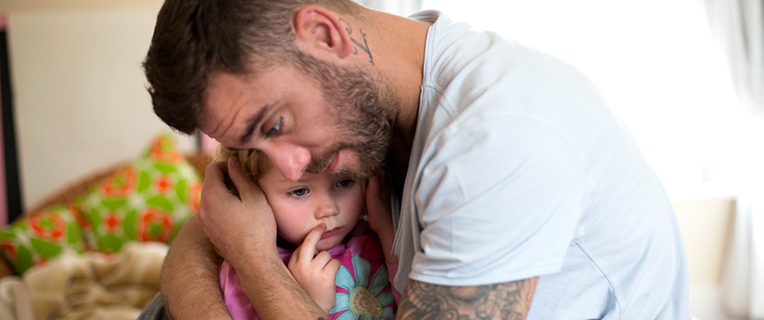 Father holding upset daughter
