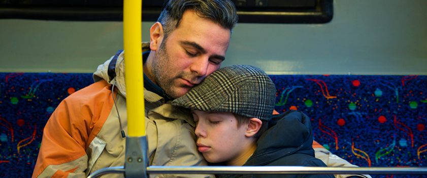 Father and son asleep on bus